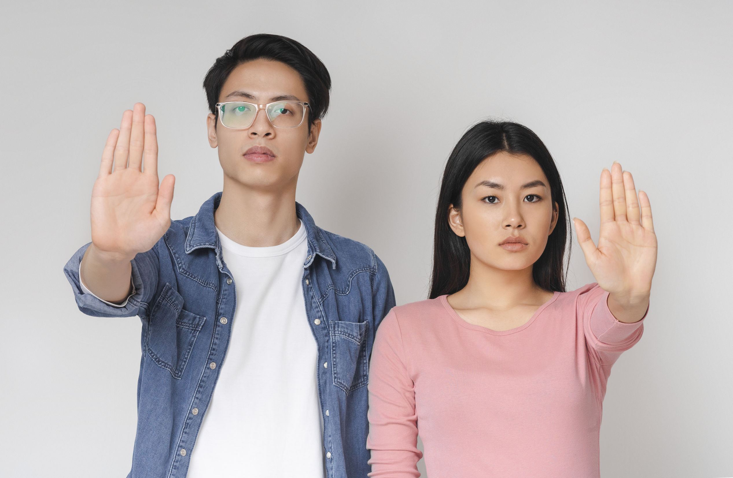 一男一女舉起手掌做出停止手勢